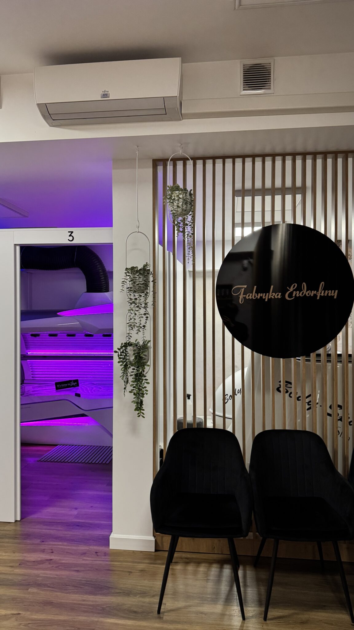 Poczekalnia salonu Fabryka Endorfiny z logo na ścianie